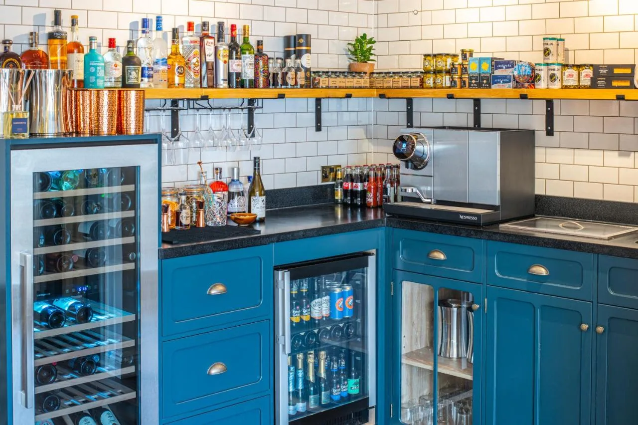 a kitchen with blue cabinets and a counter with drinks at Parador 44 in Cardiff