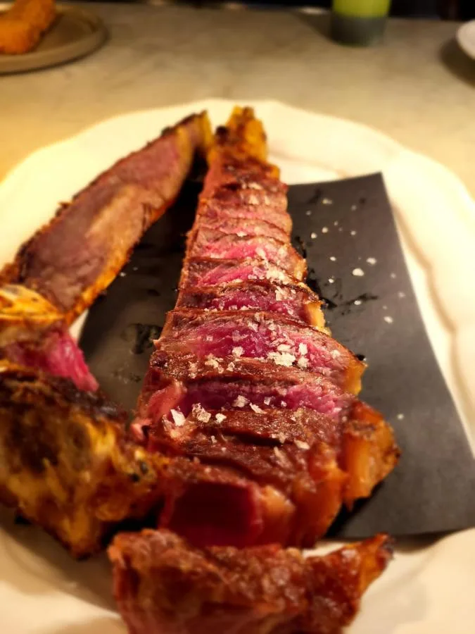 a piece of meat on a plate with a cutting board at Parador 44 in Cardiff